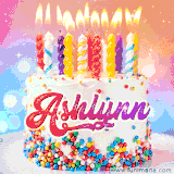 A cheerful white birthday cake with multicolor sprinkles, lit candles, and 'Ashlynn' written in vibrant letters, in an animated GIF.