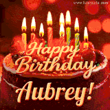 Beautifully decorated red velvet berry birthday cake with vibrant fruits and a glowing 'Aubrey' name, adding a touch of sweetness and sparkle.
