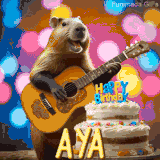 Animated birthday GIF showing a capybara playing guitar and singing beside a birthday cake with the name Aya in large letters and colorful bokeh lights in the background.