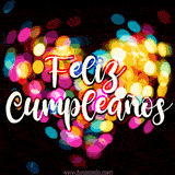 Bokeh de luces de colores en forma de corazón crea un fondo cálido y vibrante. El texto 'Feliz Cumpleaños' aparece en una fuente cursiva blanca con un toque de rojo.