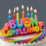 Un messaggio 'Buon compleanno!' in lettere tridimensionali arcobaleno, posto su una torta colorata con candeline accese, ideale per auguri festivi e gioiosi.