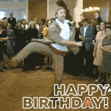 A man in a beige jacket and white shirt shows off wild dance moves at a party while guests watch, with a bold 'Happy Birthday!' message flashing on screen.