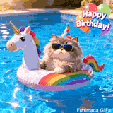 A fluffy grey cat wearing black sunglasses and a party hat floats on a white unicorn inflatable in a blue swimming pool. Balloons spell 'Happy Birthday!' nearby.