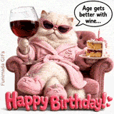 A fluffy white Persian cat in a pink bathrobe and sunglasses lounges in a chair, holding a large glass of red wine and a slice of birthday cake with a lit candle on white.