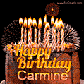 A rich chocolate cake topped with glowing birthday candles and surrounded by bright fireworks. The animated GIF displays the message 'Happy Birthday Carmine' in golden text.