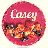 Beautifully decorated red velvet berry birthday cake with vibrant fruits and a glowing 'Casey' name, adding a touch of sweetness and sparkle.