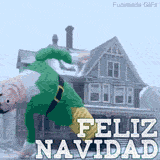 Un elfo con traje verde y mallas amarillas congelado en medio de un paso de baile acrobático frente a una casa cubierta de nieve, con el texto grande Feliz Navidad superpuesto.