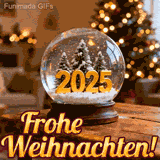 Eine Glaskugel mit Schnee steht auf einem Holztisch und enthält verschneite Tannenbäume sowie große goldene Zahlen '2025'. Im Hintergrund leuchtet ein Weihnachtsbaum mit warmen Lichtern.