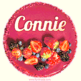 Beautifully decorated red velvet berry birthday cake with vibrant fruits and a glowing 'Connie' name, adding a touch of sweetness and sparkle.