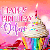 A vibrant birthday GIF featuring a rainbow-colored cupcake topped with white frosting, sprinkles, and a lit candle. The text reads 'Happy Birthday Defne' in bold pink and violet letters with white outline.