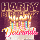 A colorful birthday cake topped with lit candles, with the words 'Happy Birthday Dezirinda' in bold glowing letters on a burgundy background. Animated flames add a festive touch.