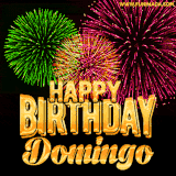 A captivating GIF with bursts of green, pink, and orange fireworks lighting up the night sky, accompanied by 'Happy Birthday Domingo' in glowing golden text.