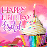A vibrant birthday GIF featuring a rainbow-colored cupcake topped with white frosting, sprinkles, and a lit candle. The text reads 'Happy Birthday Eseld' in bold pink and violet letters with white outline.