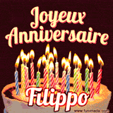 A Happy Birthday GIF in French featuring a festive birthday cake adorned with bright candles and the glowing text 'Joyeux Anniversaire Filippo' in a cheerful style.