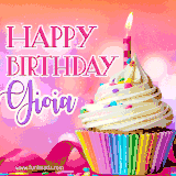 A vibrant birthday GIF featuring a rainbow-colored cupcake topped with white frosting, sprinkles, and a lit candle. The text reads 'Happy Birthday Gioia' in bold pink and violet letters with white outline.