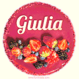Beautifully decorated red velvet berry birthday cake with vibrant fruits and a glowing 'Giulia' name, adding a touch of sweetness and sparkle.