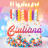 A cheerful white birthday cake with multicolor sprinkles, lit candles, and 'Giuliana' written in vibrant letters, in an animated GIF.