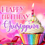 A vibrant birthday GIF featuring a rainbow-colored cupcake topped with white frosting, sprinkles, and a lit candle. The text reads 'Happy Birthday Giuseppina' in bold pink and violet letters with white outline.