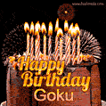 A rich chocolate cake topped with glowing birthday candles and surrounded by bright fireworks. The animated GIF displays the message 'Happy Birthday Goku' in golden text.