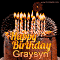 A rich chocolate cake topped with glowing birthday candles and surrounded by bright fireworks. The animated GIF displays the message 'Happy Birthday Graysyn' in golden text.