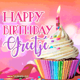 A vibrant birthday GIF featuring a rainbow-colored cupcake topped with white frosting, sprinkles, and a lit candle. The text reads 'Happy Birthday Greetje' in bold pink and violet letters with white outline.