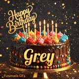 Glowing birthday candles of different colors flickering on a gourmet chocolate cake with Grey's name.