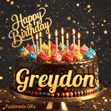 Close-up of a decorative chocolate cake with a gold Happy Birthday topper and warm glowing candle flames, made for Greydon.
