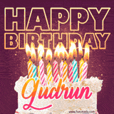 A colorful birthday cake topped with lit candles, with the words 'Happy Birthday Gudrun' in bold glowing letters on a burgundy background. Animated flames add a festive touch.