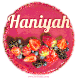 Beautifully decorated red velvet berry birthday cake with vibrant fruits and a glowing 'Haniyah' name, adding a touch of sweetness and sparkle.