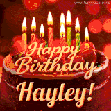 Beautifully decorated red velvet berry birthday cake with vibrant fruits and a glowing 'Hayley' name, adding a touch of sweetness and sparkle.