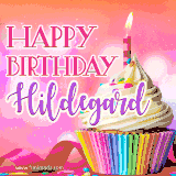 A vibrant birthday GIF featuring a rainbow-colored cupcake topped with white frosting, sprinkles, and a lit candle. The text reads 'Happy Birthday Hildegard' in bold pink and violet letters with white outline.