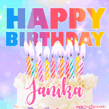 A vibrant animated name GIF with the words 'Happy Birthday Janika' with colorful candles on a creamy cake. The background sparkles with pastel shades, adding a festive touch.