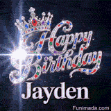 Close-up of a silver crown with emeralds, rubies, and sapphires resting on crystal-encrusted Happy Birthday text.Jayden