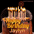 A rich chocolate cake topped with glowing birthday candles and surrounded by bright fireworks. The animated GIF displays the message 'Happy Birthday Jaylyn' in golden text.