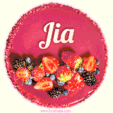 Beautifully decorated red velvet berry birthday cake with vibrant fruits and a glowing 'Jia' name, adding a touch of sweetness and sparkle.