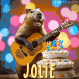Animated birthday GIF showing a capybara playing guitar and singing beside a birthday cake with the name Jolie in large letters and colorful bokeh lights in the background.