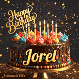 Yellow script spelling the name Jorel on a classic chocolate cake with a dark glaze under warm candlelight.