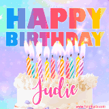 A vibrant animated name GIF with the words 'Happy Birthday Judie' with colorful candles on a creamy cake. The background sparkles with pastel shades, adding a festive touch.