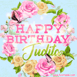 A charming animated GIF featuring 'Happy Birthday Judita' in pink and green text, surrounded by delicate roses, leaves, and fluttering butterflies on a soft light blue pastel background.