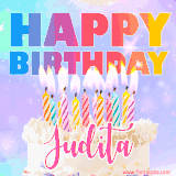 A vibrant animated name GIF with the words 'Happy Birthday Judita' with colorful candles on a creamy cake. The background sparkles with pastel shades, adding a festive touch.