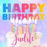A vibrant animated name GIF with the words 'Happy Birthday Judite' with colorful candles on a creamy cake. The background sparkles with pastel shades, adding a festive touch.