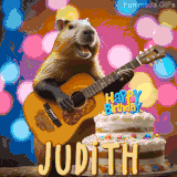 Animated birthday GIF showing a capybara playing guitar and singing beside a birthday cake with the name Judith in large letters and colorful bokeh lights in the background.