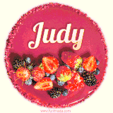 Beautifully decorated red velvet berry birthday cake with vibrant fruits and a glowing 'Judy' name, adding a touch of sweetness and sparkle.