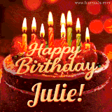 Beautifully decorated red velvet berry birthday cake with vibrant fruits and a glowing 'Julie' name, adding a touch of sweetness and sparkle.