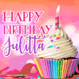 A vibrant birthday GIF featuring a rainbow-colored cupcake topped with white frosting, sprinkles, and a lit candle. The text reads 'Happy Birthday Julitta' in bold pink and violet letters with white outline.