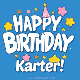 A gold and white glazed birthday cake with blue lettering spelling Karter, surrounded by colorful party decorations.