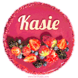 Beautifully decorated red velvet berry birthday cake with vibrant fruits and a glowing 'Kasie' name, adding a touch of sweetness and sparkle.