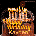 A rich chocolate cake topped with glowing birthday candles and surrounded by bright fireworks. The animated GIF displays the message 'Happy Birthday Kayden' in golden text.