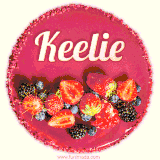Beautifully decorated red velvet berry birthday cake with vibrant fruits and a glowing 'Keelie' name, adding a touch of sweetness and sparkle.