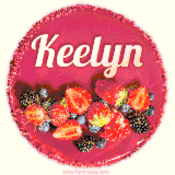 Beautifully decorated red velvet berry birthday cake with vibrant fruits and a glowing 'Keelyn' name, adding a touch of sweetness and sparkle.